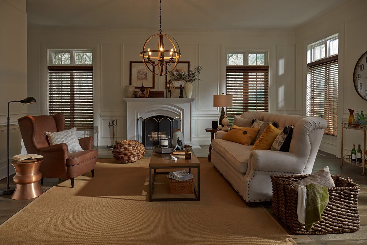 Living room with warm color accents and wooden blinds partially open